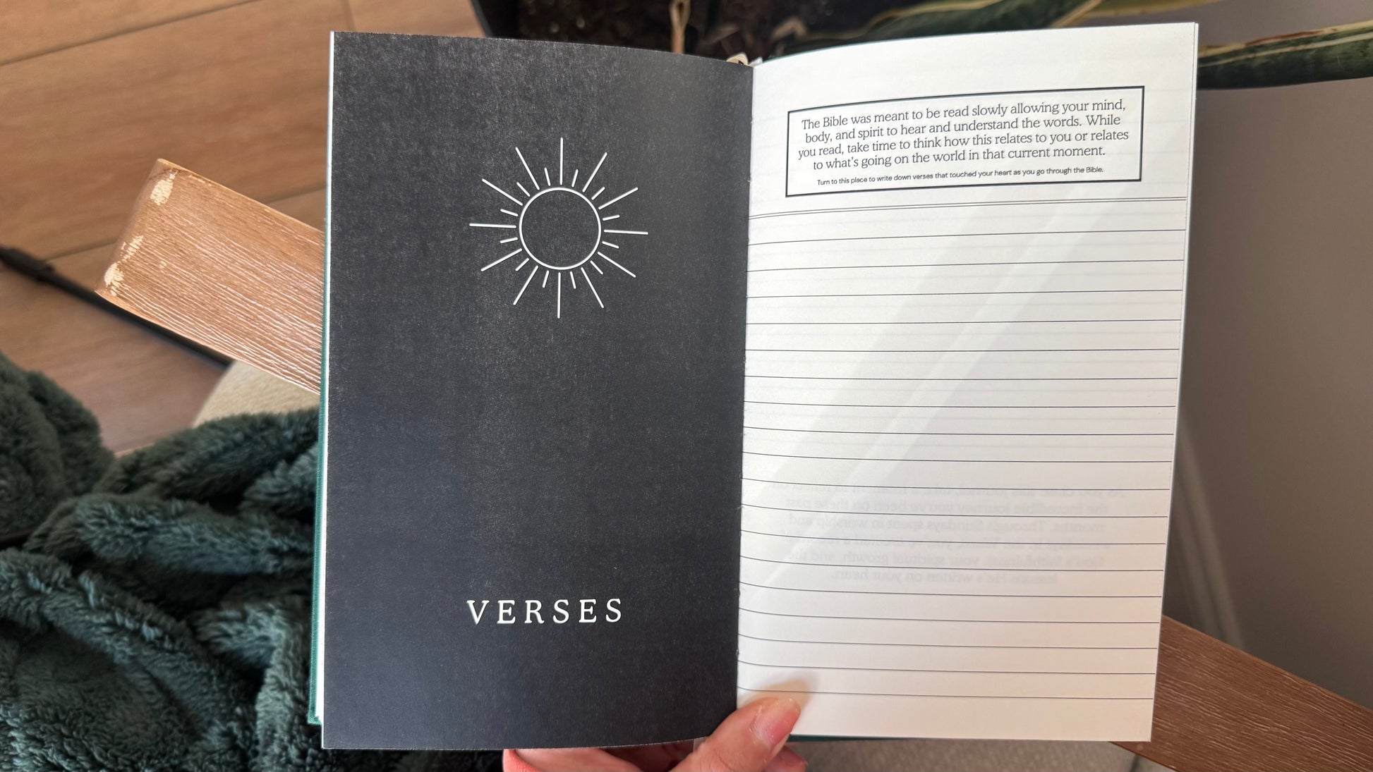 Notebook titled 'VERSES' with a sun symbol on a wooden surface